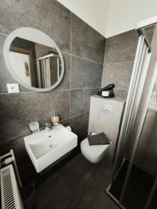 a bathroom with a sink and a toilet and a mirror at Hotel am Stadtpark Nordhausen in Nordhausen