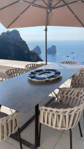 uma mesa azul com cadeiras e um guarda-sol em Villa le gradelle with amazing view em Capri