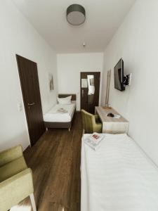 Cette petite chambre comprend 2 lits et un lavabo. dans l'établissement Hotel am Stadtpark Nordhausen, à Nordhausen
