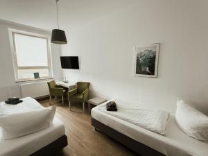 a room with a bed and a desk and a table at Hotel am Stadtpark Nordhausen in Nordhausen