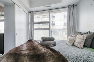 a bedroom with a bed with a large window at Waterfront High Rise Condo Downtown in Toronto