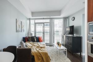 uma sala de estar com um sofá e uma televisão em Waterfront High Rise Condo Downtown em Toronto