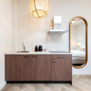 ein Bad mit einem Waschbecken und einem Spiegel in der Unterkunft Grapèlli Boutique Hotel in Alkmaar