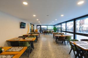 een restaurant met houten tafels en stoelen en ramen bij Berlin Suite Hotel Trabzon in Trabzon