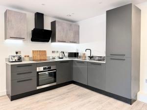 een keuken met grijze kasten en een fornuis bij Apartment 30 City gate in York
