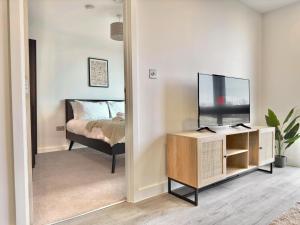 een slaapkamer met een bed en een televisie in een spiegel bij Apartment 30 City gate in York