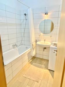 a bathroom with a tub and a sink and a mirror at Budapest Opera Apartment in Budapest