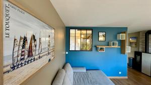 una habitación con una pared azul con una gran pintura en Cottage les Pins, en Stella-Plage