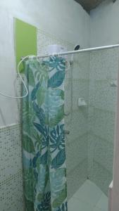 uma casa de banho com um chuveiro com uma cortina de chuveiro verde em Punta Pacífico Bungalows Máncora em Máncora