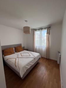um quarto branco com uma cama e uma janela em Appartement 4pax : Parking, balcon, climatisation. em Boulogne-Billancourt