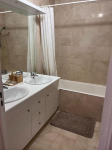 uma casa de banho com um lavatório e uma banheira em Appartement 4pax : Parking, balcon, climatisation. em Boulogne-Billancourt