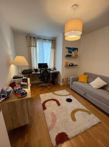 uma sala de estar com um sofá e uma mesa em Appartement 4pax : Parking, balcon, climatisation. em Boulogne-Billancourt