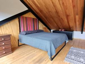 una camera con letto e soffitto in legno di Casa de montaña La Cumba Patagonia. a San Martín de los Andes