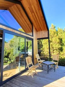 un patio avec des chaises et une table sur une terrasse dans l'établissement Casa de montaña La Cumba Patagonia., à San Martín de los Andes