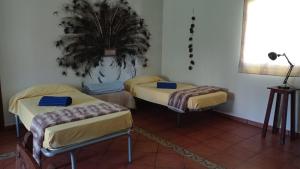 una habitación con 3 camas y una planta en la pared en El amanecer, en El Puerto de Santa María