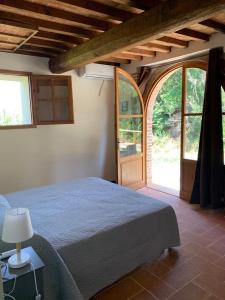 a bedroom with a bed and an open door at Agriturismo Diffuso Monte Oliveto Maggiore in Chiusure
