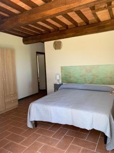 a bedroom with a bed with a painting on the wall at Agriturismo Diffuso Monte Oliveto Maggiore in Chiusure