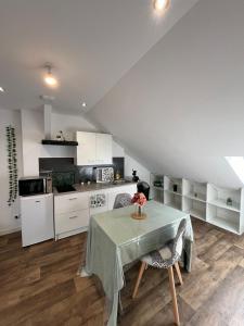 una cocina con una mesa con un jarrón de flores. en Le garden cottage 20m² 2 personnes en Flers-lez-Lille