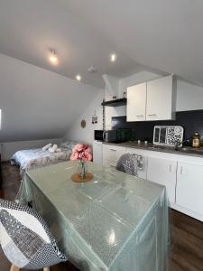 eine Küche mit einem Tisch und Stühlen im Zimmer in der Unterkunft Le garden cottage 20m² 2 personnes in Flers-lez-Lille