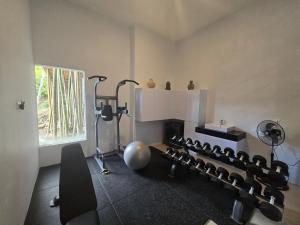 una habitación con un gimnasio con un montón de equipamiento en Ocean Wave Lombok - 4 BR infinity pool villa, en Selong Belanak