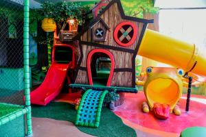 a playground with a toy house and a slide at Hotel Fazenda Vista Alegre in São Lourenço