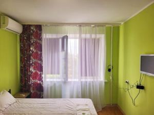 a bedroom with a bed and a window with a television at Квартира на Слобожанському Сomfort24 Slobozhansky 67 avenue in Dnipro