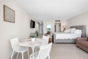 sala de estar con cama, mesa y sillas en Your Ocean Zen Oasis, en Fajardo