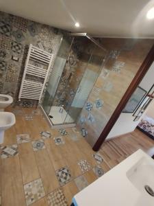 baño con ducha y suelo de madera. en Loft americano in villa, en Aprilia