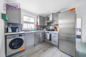 a kitchen with a washer and dryer in it at Centrally Located Serviced Apartments in Aldershot Town Centre, Free WiFi By Redwood Stays in Aldershot