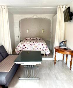 ein Schlafzimmer mit einem Bett, einem Sofa und einem Tisch in der Unterkunft Le Gîte du Sommerberg in Niedermorschwihr