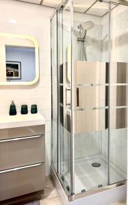 y baño con ducha y puerta de cristal. en Le Gîte du Sommerberg en Niedermorschwihr