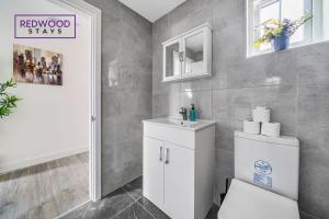 bagno con servizi igienici bianchi e lavandino di BRAND NEW, 1 Bed 1 Bath, Modern Town Center Apartment, FREE WiFi & Netflix By REDWOOD STAYS ad Aldershot