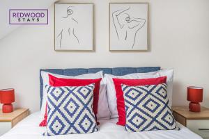 una camera da letto con letto con cuscini rossi e disegni sul muro di BRAND NEW, 1 Bed 1 Bath, Modern Town Center Apartment, FREE WiFi & Netflix By REDWOOD STAYS ad Aldershot