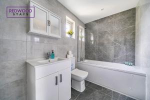 a bathroom with a sink and a toilet and a bath tub at Centrally Located Serviced Apartments in Aldershot Town Centre, Free WiFi By Redwood Stays in Aldershot