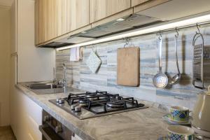 a kitchen counter with a stove and a sink at The Rising Sun in Marinella di Selinunte