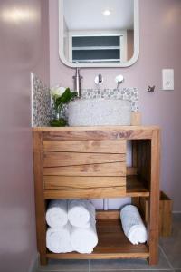 ein Badezimmer mit einem Waschbecken und einem Stapel Handtücher in der Unterkunft Bulle d'eden in La Seyne-sur-Mer