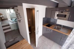 a small kitchen with gray cabinets and a microwave at Bulle d'eden in La Seyne-sur-Mer