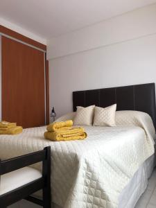 圣罗莎Departamento Urquiza II的一间卧室配有一张大床,床上配有黄色毛巾