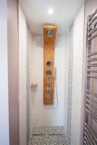 濱海拉塞訥的住宿－Bulle d'eden，墙上的时钟和带淋浴的浴室