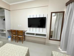 a living room with a flat screen tv and a mirror at Spazzio Diroma Com acesso gratuito ao Acqua Park - R in Caldas Novas
