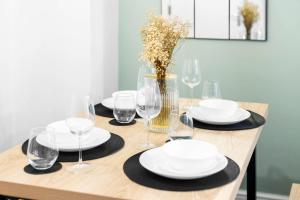 stół z talerzami i okularami oraz wazon z kwiatami w obiekcie Luxury 3 Bedroom House - Harborne - Garden - Sleeps 7 - Wifi - Netflix - Parking - 465H w Birmingham
