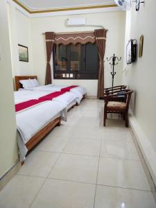 um quarto com 2 camas e uma cadeira em Hotel Cao Nguyên em Dồng Văn