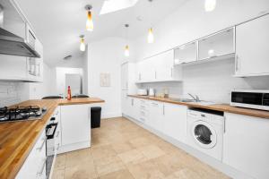 a kitchen with white cabinets and a washer and dryer at Luxury 3 Bedroom House - Harborne - Garden - Sleeps 7 - Wifi - Netflix - Parking - 465H in Birmingham