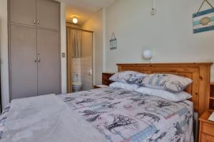 a bedroom with a large bed with pillows on it at Beach Bliss in Amanzimtoti