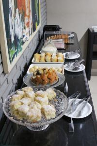 a buffet with several plates of food on a table at Premier Hotel in Votuporanga