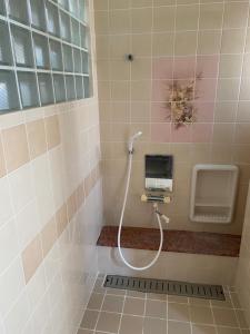 łazienka z prysznicem i umywalką w obiekcie Joyful Rose w mieście Ginowan