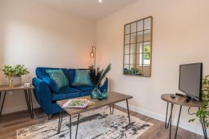 a living room with a blue couch and a tv at Larkswood Annex in Bradpole