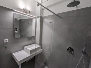 a bathroom with a sink and a mirror at Corfu Garitsa Spacious Apartment in Corfu +15 photos