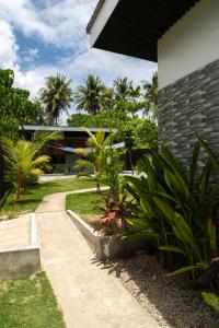 a walkway next to a house with palm trees at Amara Pool & Villas 180Mbps Central location in General Luna