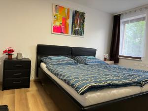 a bed with a blue comforter in a bedroom at Pension Sachseneck in Heidenau